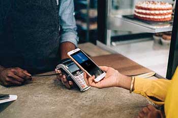 Cliente usando la billetera móvil de Security Federal Savings Bank con Apple Pay o Google Pay en una panadería local